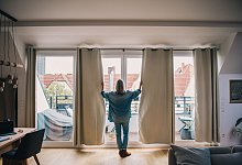 Eine Frau schleißt Gardinen - Zacharie Scheurer/dpa-tmn