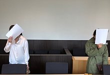 Die beiden angeklagten Schwestern stehen im Gerichtssaal. - Frank Christiansen/dpa