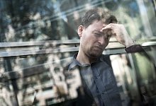 Mann h&auml;lt sich mit der Hand seinen schmerzenden Kopf - Alexander Heinl/dpa-tmn