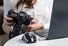 Eine Frau mit Kamera vor einem Notebook - Christin Klose/dpa-tmn