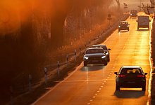 Autos fahren bei aufgehender Sonne auf einer Landstra&szlig;e - Thomas Warnack/dpa/dpa-tmn