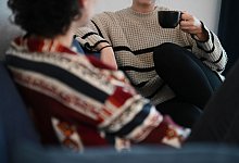 Zwei Frauen sitzen auf einem Sofa - Alicia Windzio/dpa/dpa-tmn