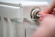 Frau entlüftet einen Heizkörper - Andrea Warnecke/dpa-tmn