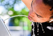 Ein Hobbysportler trinkt aus einem Trinkbrunnen - Julian Stratenschulte/dpa/dpa-tmn