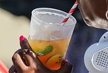 Eine Frau trinkt aus einem Getränkebecher - Frank Molter/dpa/dpa-tmn