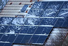 Eine d&uuml;nne Schneedecke auf einer Solaranlage - Jan Woitas/dpa/dpa-tmn