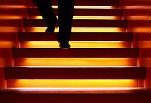 Mann geht eine angeleuchtete Treppe hinab - Fredrik von Erichsen/dpa/dpa-tmn