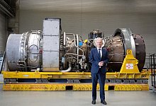 Bundeskanzler Olaf Scholz vor der in Kanada f&uuml;r die Erdgas-Pipeline Nordstream 1 gewarteten Turbine. - Bernd Thissen/dpa