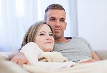 Ein Paar kuschelt auf einer Couch - Christin Klose/dpa-tmn