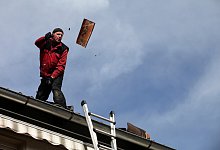 Defekte Pfannen fliegen im hohen Bogen vom Dach. - Bernhard Preuss