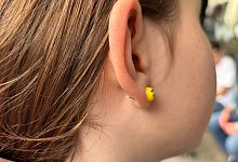 Ein junges M&auml;dchen tr&auml;gt einen Ohrstecker - Tom Nebe/dpa-tmn