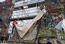 Documenta-Mitarbeiter bauen das umstrittene Gro&szlig;banner "People\\\'s Justice" auf dem Friedrichsplatz ab. - Uwe Zucchi/dpa