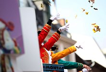 Von einem Karnevalswagen werden Kamelle geworfen - Oliver Berg/dpa/dpa-tmn