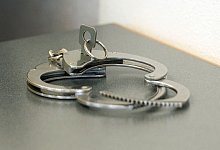 Handschellen auf einem Tisch - Armin Weigel/dpa