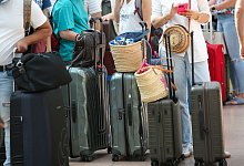 Reisende warten im Terminal auf die Abfertigung - Bodo Marks/dpa