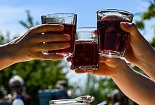 Personen stoßen an - Jens Kalaene/dpa/dpa-tmn