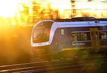 Zug der NordWestBahn im Sonnenaufgang - Sina Schuldt/dpa/dpa-tmn