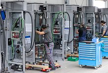 Mitarbeiter verdrahten im Leipziger Siemens-Werk Ladesysteme f&uuml;r Elektroautos. Bei der Angleichung der Arbeitszeiten ans West-Niveau sind die Betriebe der Metall- und Elektroindustrie in Ostdeutschland aus Sicht der IG Metall auf einem guten Weg. - Jan Woitas/dpa