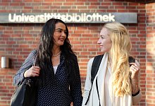 Zwei Frauen laufen eber den Campus der Universitaet - Markus Hibbeler/dpa-tmn