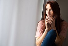 Frau schaut aus Fenster - Franziska Gabbert/dpa-tmn