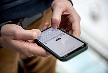 Ein Mann tippt eine Nachricht auf einem iPhone 12 - Zacharie Scheurer/dpa-tmn