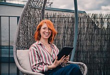 Eine Frau hält ein Tablet in den Händen - Zacharie Scheurer/dpa-tmn