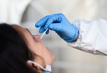 Eine Mitarbeiterin eines Testzentrums entnimmt einer Frau einen Nasenabstrich f&uuml;r einen Corona-Test. - Kira Hofmann/dpa-Zentralbild/dpa/Symbolbild