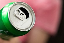 Mann hält Getränkedose in der Hand - Alexander Heinl/dpa-tmn