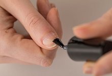 Eine Frau trägt transparenten Nagellack auf - Christin Klose/dpa-tmn