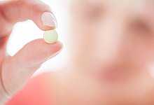 Frau h&auml;lt Tablette zwischen den Fingern - Christin Klose/dpa-tmn