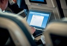 Laptop im Flugzeug - Foto: Michael Kappeler/dpa