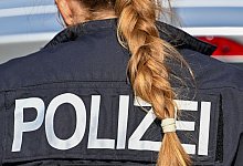 Der Zopf einer Polizistin hängt über ihre Uniform. - Soeren Stache/dpa