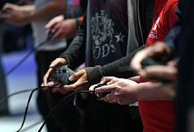 Gamer mit Controller - Foto: Henning Kaiser/dpa-tmn