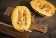 Ein aufgeschnittener Spaghetti-Kürbis liegt auf einem Brett - Christin Klose/dpa-tmn