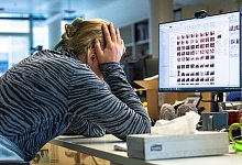 Eine Frau sitzt an ihrem Arbeitsplatz - Bernd Diekjobst/dpa-tmn