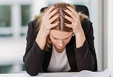 Frau st&uuml;tzt ersch&ouml;pft den Kopf in die H&auml;nde - Monique W&uuml;stenhagen/dpa-tmn