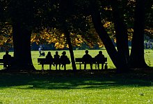 Menschen sitzen auf Parkbänken - Inga Kjer/dpa/dpa-tmn