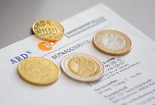 Münzen auf einem Brief vom Beitragsservice - Foto: Fernando Gutierrez-Juarez/dpa-Zentralbild/dpa-tmn