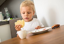 Kleinkind isst eine Reiswaffel - Christin Klose/dpa-tmn