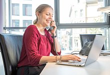 Eine Frau telefoniert und arbeitet am Laptop im Büro - Christin Klose/dpa-tmn