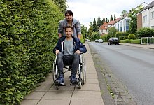 Los geht’s, anders als gewohnt: Frederik schiebt Marius im Rollstuhl aufdem Fußgängerweg zur Stadtbahnhaltestelle Friedrich-List-Straße. - Ivonne Michel/privat