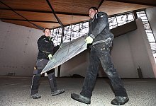 Beim Fensterausbau: Die bleiverglasten St&uuml;cke werden von Dominic Kreuzer (links) und Mathias Gro&szlig;e Wietfeld vorsichtig demontiert. Vier Fl&uuml;gel k&ouml;nnen gerettet werden. Foto: Vera Gerstendorf-Welle - Vera Gerstendorf-Welle