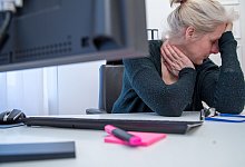 Eine Frau st&uuml;tzt ihren Kopf auf die Hand am Arbeitsplatz - Christin Klose/dpa-tmn