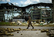 Ein ukrainischer Soldat geht an einer durch Beschuss zerst&ouml;rten Fabrik vorbei. - Francisco Seco/AP/dpa
