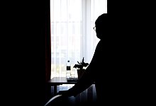 Ein Senior steht in einem Raum am Fenster - Sina Schuldt/dpa/dpa-tmn