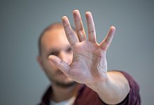 Ein Mann hebt schützend die Hand vor sein Gesicht - Andrea Warnecke/dpa-tmn