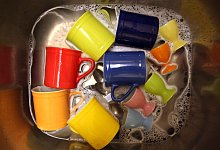 Buntes Geschirr liegt in einem Spülbecken - Karl-Josef Hildenbrand/dpa/dpa-tmn