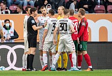 Schiedsrichter Matthias J&ouml;llenbeck (l) spricht mit den Spielern. - Matthias Balk/dpa