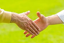 Hände reichen - Foto: Mohssen Assanimoghaddam/dpa