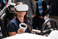 Eine Frau sitzt am Stand der Firma Siemens im vollelektrischen Fahrzeug SimRod. - Swen Pförtner/dpa